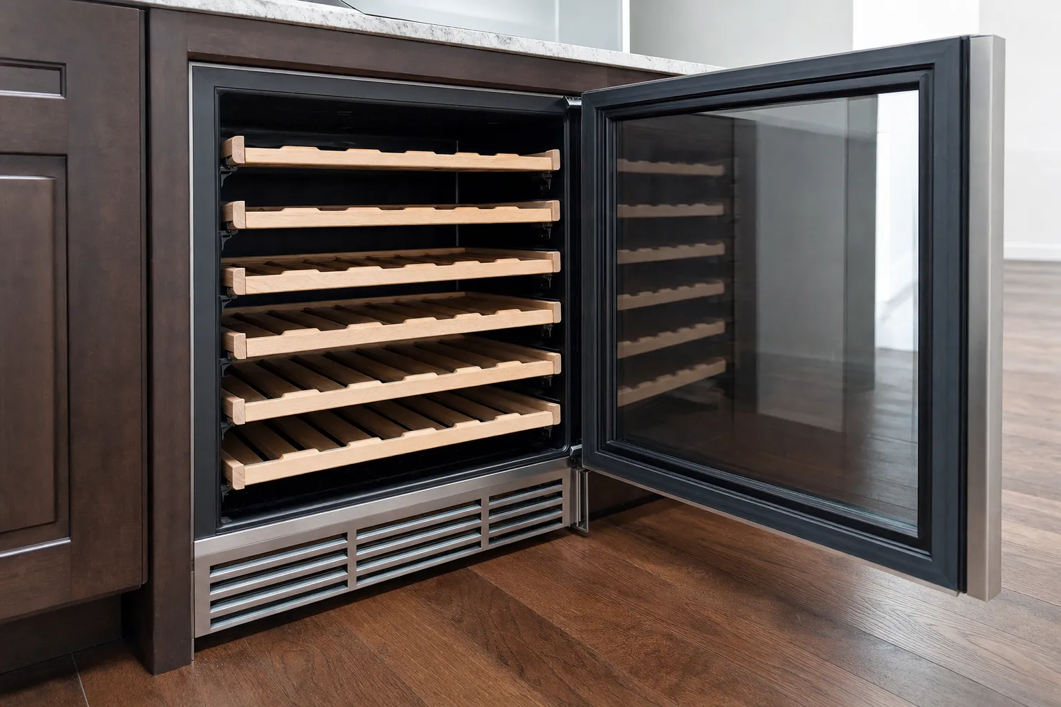 Undercounter wine cabinet with its glass door open on empty wooden bottle shelves